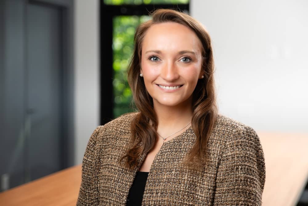 Smiling woman with brown hair and brown suit
