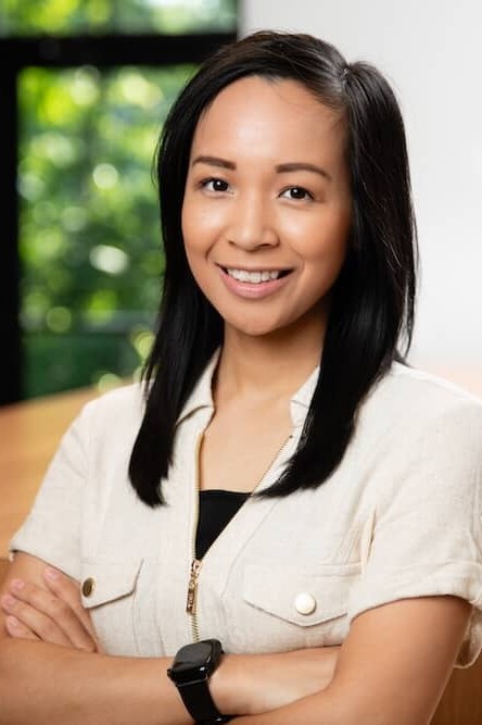 Smiling young woman with dark hair and tan shirt