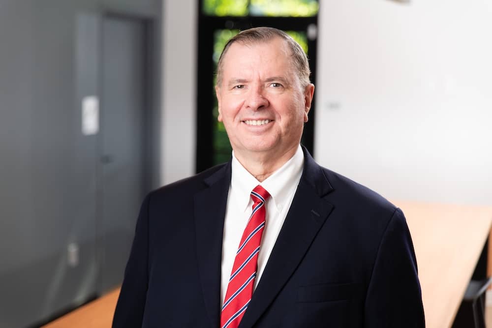 Smiling older man in suit and red striped tie